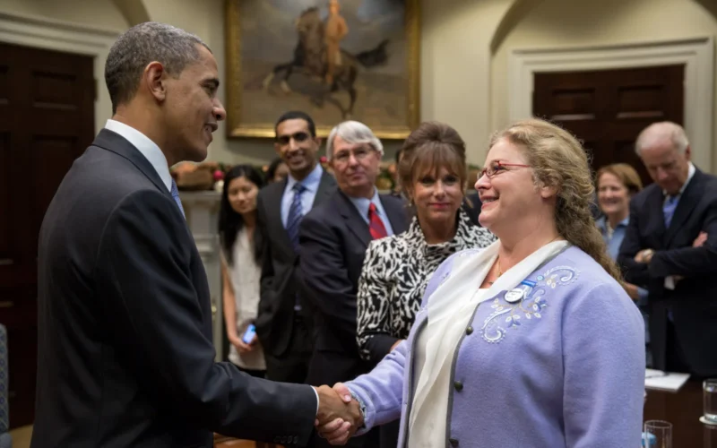 United States President Barack Obama talks with participants before a meeting with small business owners to discuss a balanced approach to the debt limit and deficit reduction, in the Roosevelt Room of the White House. The President is shaking hands with Deborah Carey, co-founder of Wisconsin's New Glarus Brewing Company, who is wearing a "Brewers for Barack" badge.