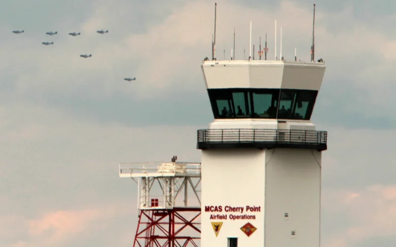 The air traffic control tower sits in the foreground as seven EA-6B Prowlers with Marine Tactical Electronic Warfare Training Squadron 1 take part in an historic seven aircraft flyover of Marine Corps Air Station Cherry Point, N.C., Oct. 16, 2014. The flyover was a first in Marine Corps aviation. Never before have Prowler pilots performed a formation flyover with seven aircraft. VMAQT-1 was recognized recently with the Outstanding Unit Award by the Association of Old Crows for excellence in the performance of electronic warfare during calendar year 2013. The AOC is an association of U.S. government defense, civil industry and academic professionals dedicated to advancing the technical and scientific contributions of electronic warfare and information operations in support of national defense.