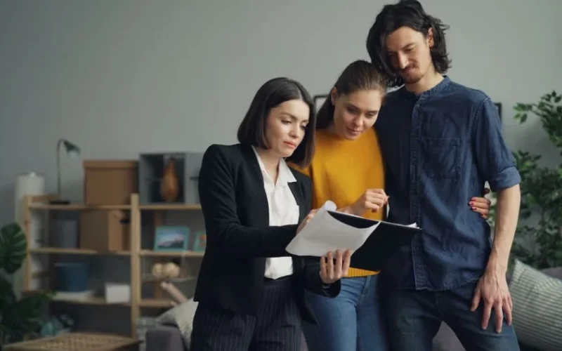 Young couple consulting with a real estate agent about property one indoors.
