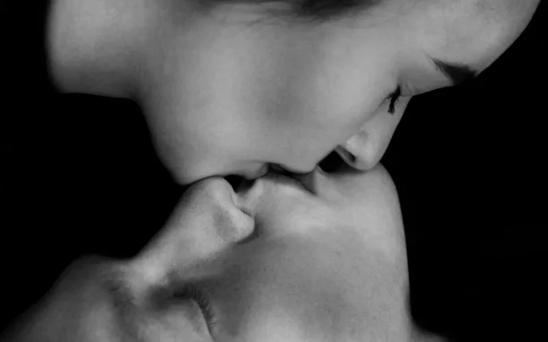 Emotional black and white close-up of a couple sharing an intimate kiss, capturing raw love.