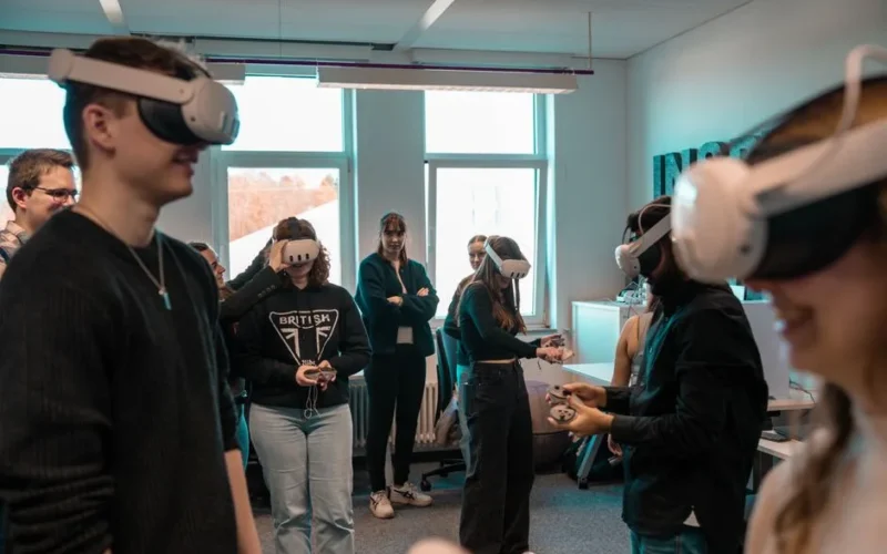 A group of diverse adults using VR headsets in an office setting.