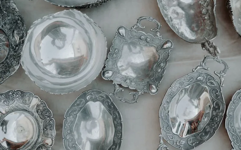 A sophisticated assortment of vintage silver metalware beautifully arranged in an overhead view, showcasing ornate designs.