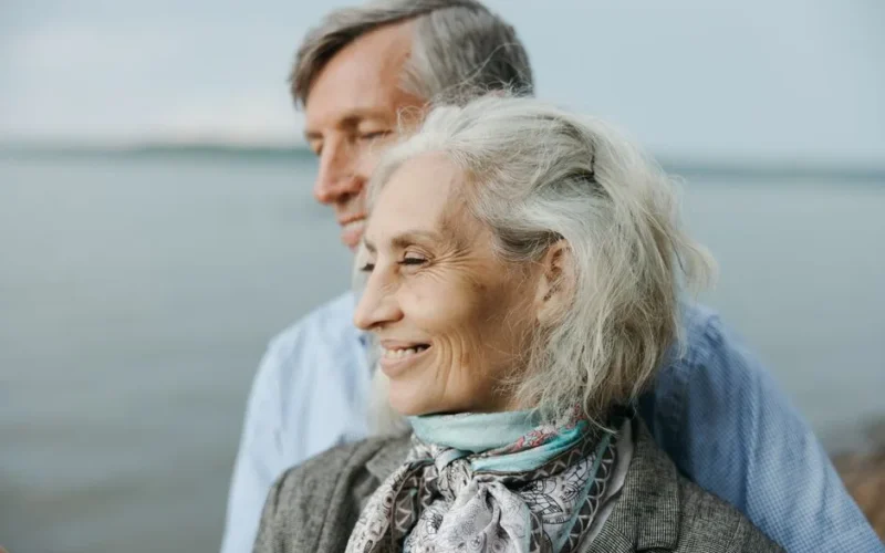 Senior couple sharing a romantic moment by the lake, showcasing love and togetherness.