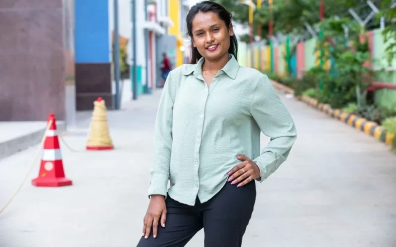 Portrait of a confident woman standing outdoors on a vibrant city street.