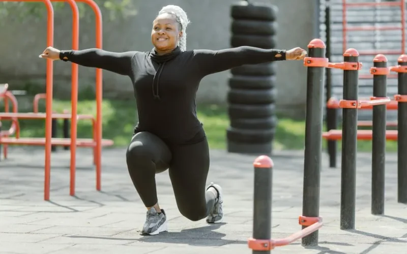 African American woman exercising in a park, promoting a healthy lifestyle.