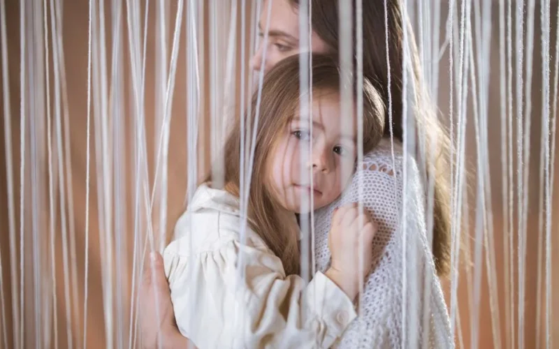 A warm embrace captures the bond between mother and daughter, creating a tender and intimate moment.