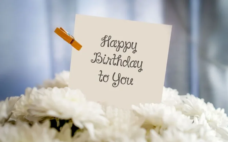 A birthday card with 'Happy Birthday to You' text amidst white flowers for a cheerful celebration.