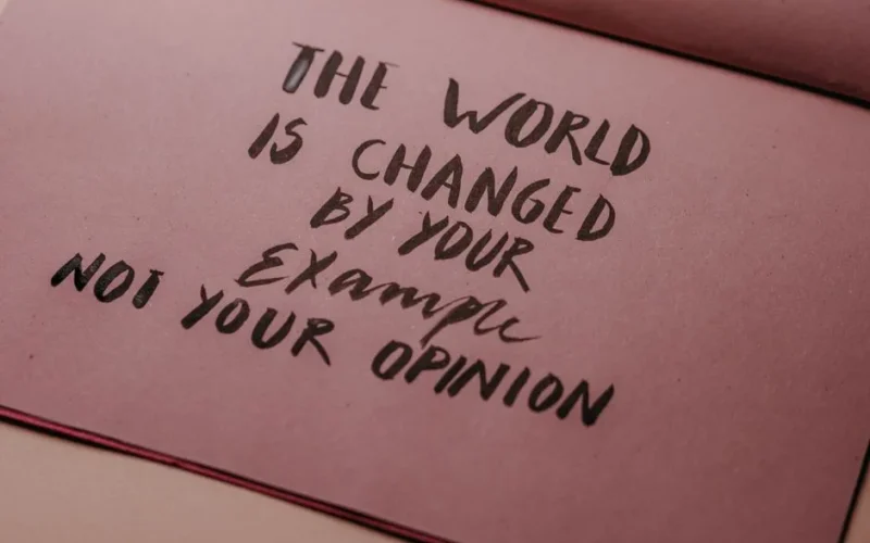 Motivational phrase emphasizing actions over words displayed on textured paper.