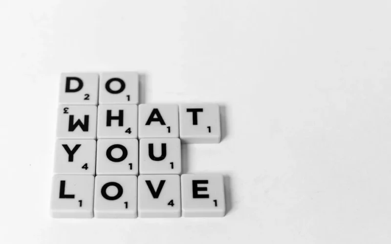 Scrabble tiles spelling 'Do What You Love'. Motivational and creative concept visual.
