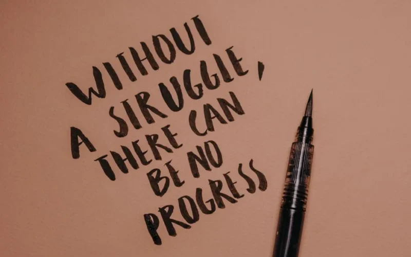 Handwritten motivational quote using a brush pen on a textured background for inspiration.