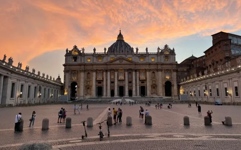Stunning view of St. Peter's Basilica and Vatican City at sunset with vibrant skies.
