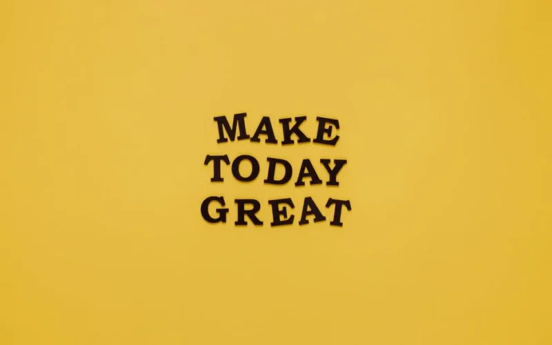 Simple and motivational quote 'Make Today Great' on a minimalist yellow background for inspiration.