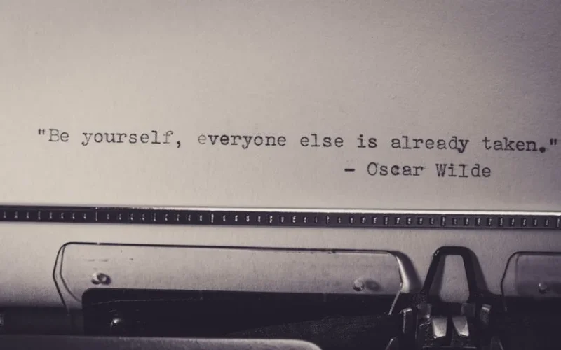 Vintage typewriter displaying Oscar Wilde's quote 'Be yourself, everyone else is already taken.'