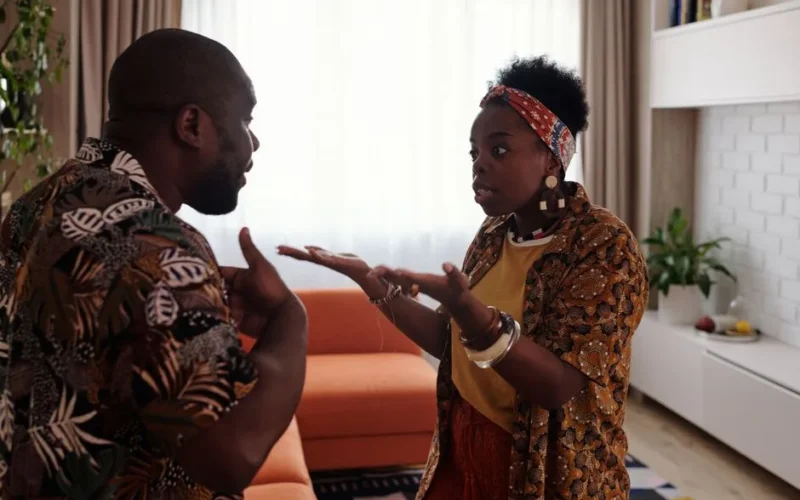 A couple arguing passionately in their living room, expressing emotions and gestures.