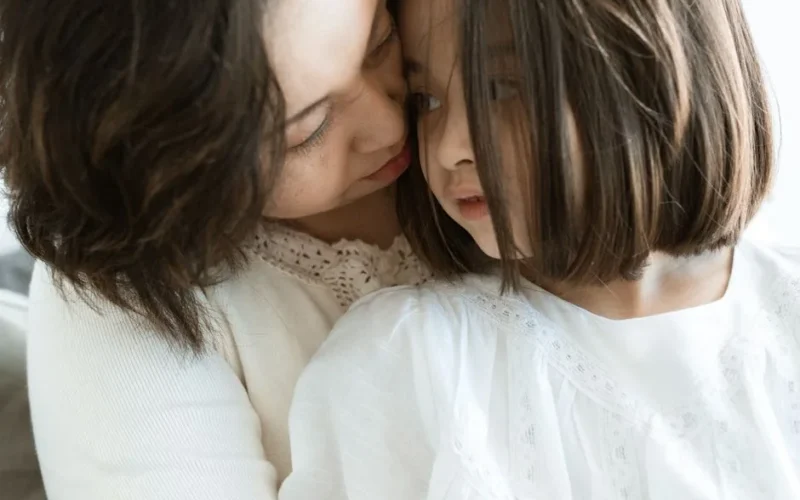 Tender moment between mother and daughter, highlighting love and connection.