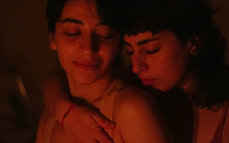 A warm, intimate embrace between two women, capturing a moment of affection and connection.