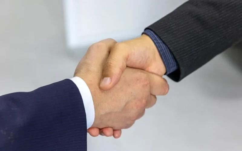 Close-up of two businessmen shaking hands, symbolizing agreement and partnership.