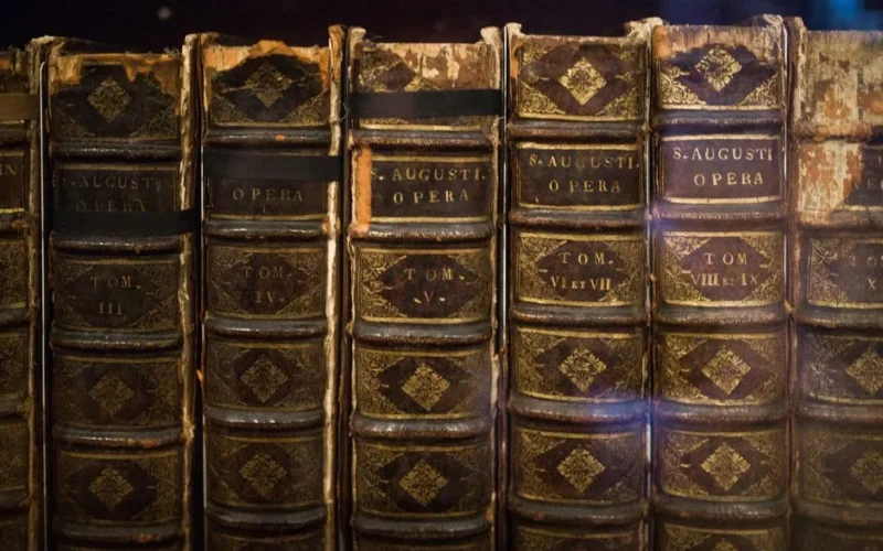 Close-up of vintage St. Augustine's Opera books, showcasing their aged and classic bindings.