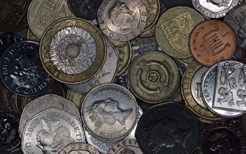 Close-up image of various British coins showing diverse designs and denominations.