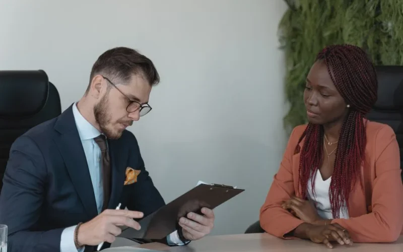 A man and woman engaging in a job interview in a modern office setting.