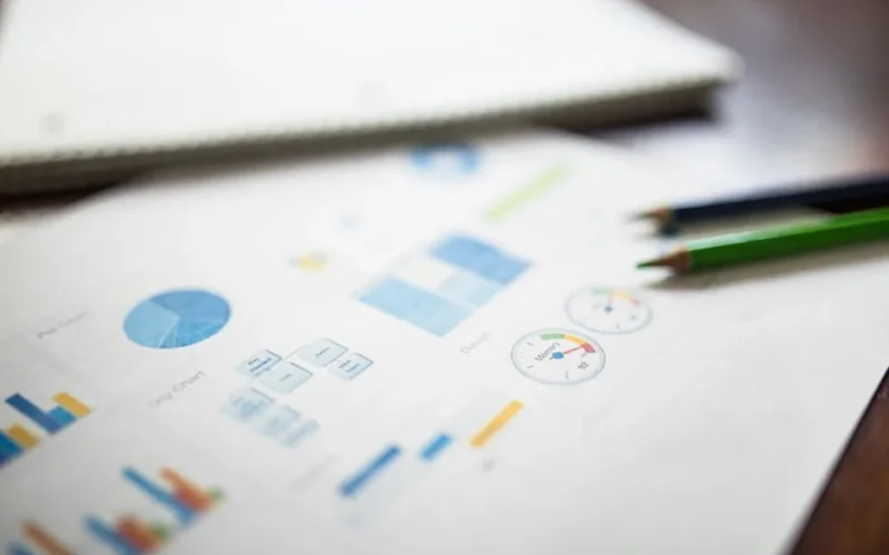 Illustration of a business financial report featuring various charts and graphs on paper.
