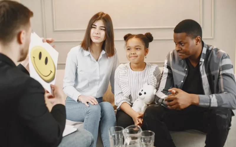 A family therapy session with a therapist, featuring parents and a child engaging in discussion.