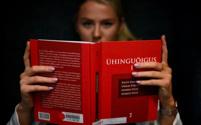 A law student intensely reading a legal textbook indoors in Tallinn, Estonia.