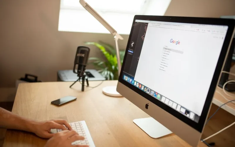 A modern workspace with an iMac displaying Google search, perfect for remote work setups.
