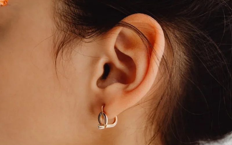 Detailed close-up of a woman's ear adorned with a stylish earring.