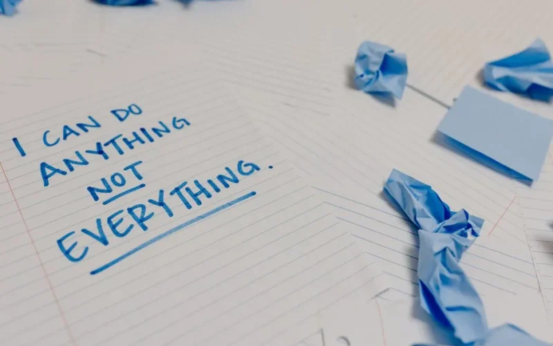 Motivational message on a page surrounded by crumpled papers and blue sticky notes.
