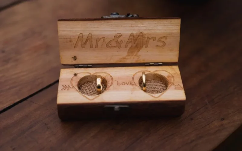 Elegant wedding rings displayed in a rustic wooden box engraved with Mr & Mrs.