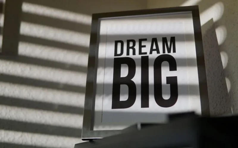Framed motivational 'Dream Big' text art creates an inspiring indoor ambiance.