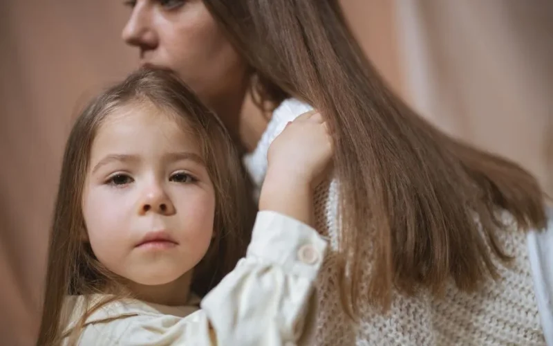 Tender moment between a mother and child embracing indoors, capturing love and connection.