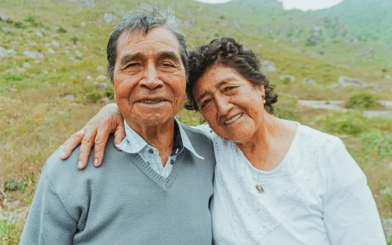 Smiling senior couple embracing in a scenic outdoor setting, expressing love and happiness.