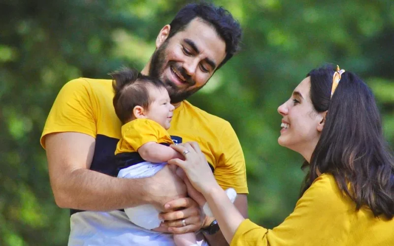 A happy family shares a joyful moment outdoors, depicting love and togetherness.