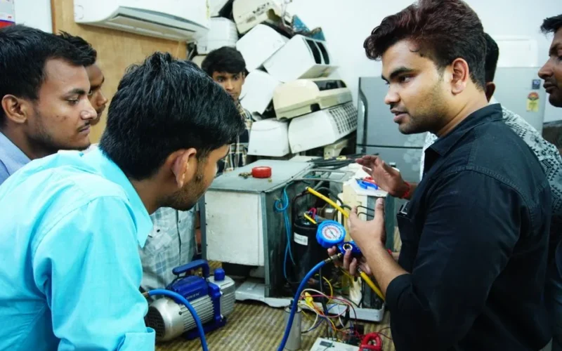 Participants learn AC repair during a hands-on session in Delhi, India.