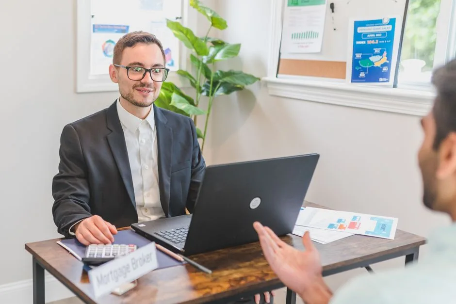 A mortgage broker and client discussing loan options in a modern office setting.