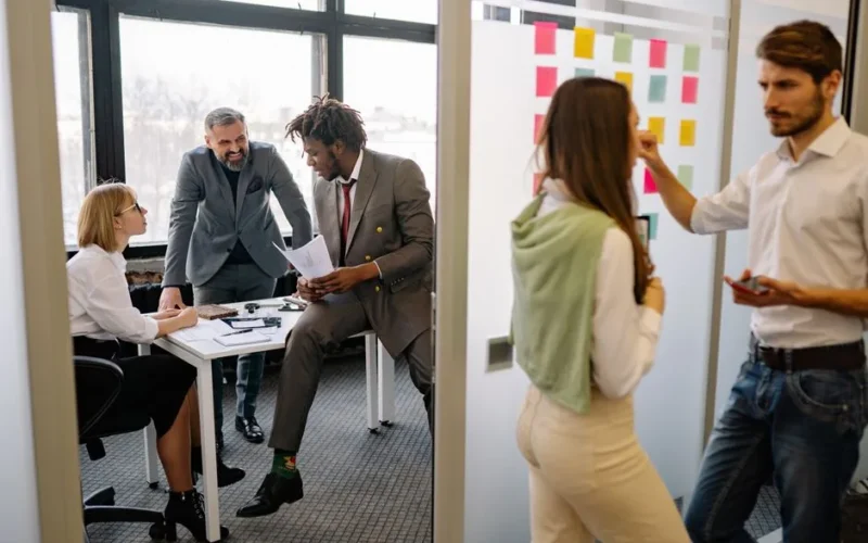 Office environment with diverse team members brainstorming and collaborating on a project.
