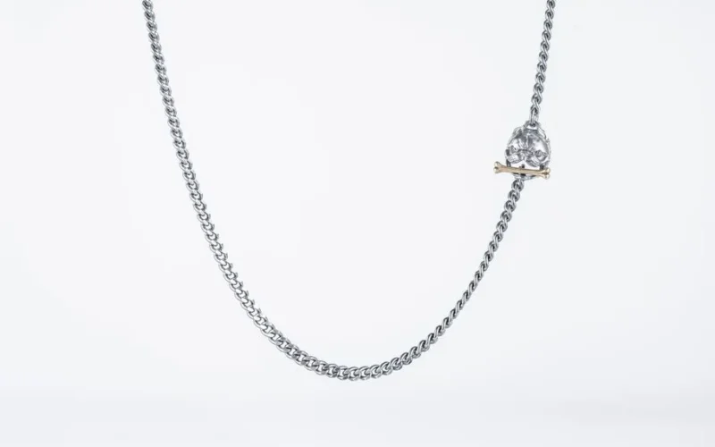 Detailed image of a stylish silver Cuban link chain necklace with a bulldog pendant on a white background.