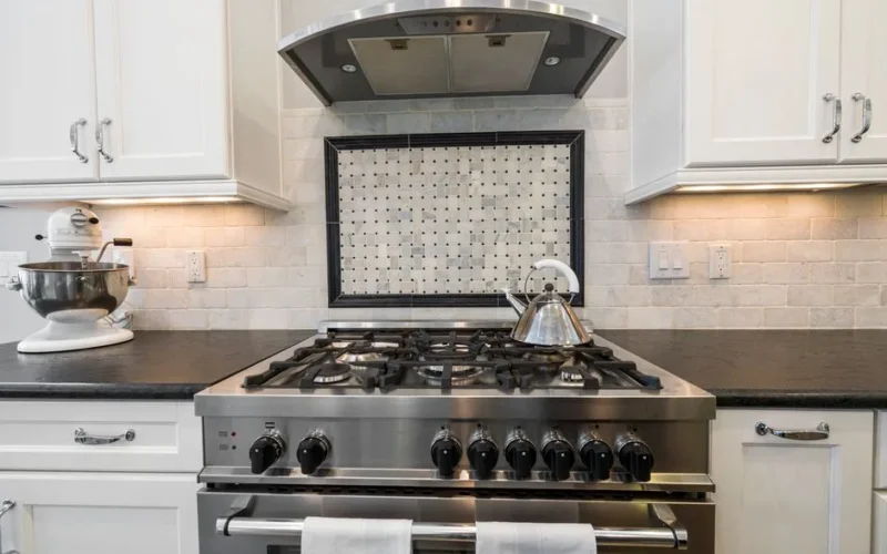 Contemporary kitchen featuring a stainless steel stove and kettle with sleek cabinetry.