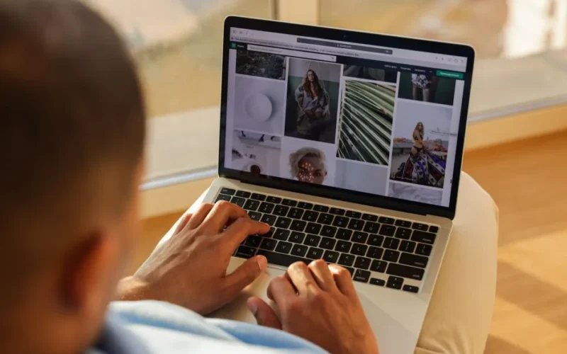Close-up of a person using a laptop indoors while browsing a photography portfolio.